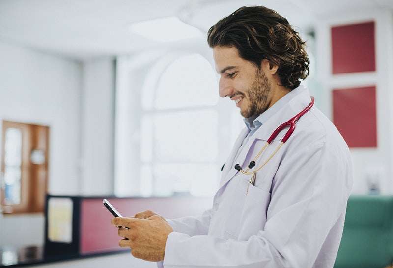 Male doctor using his smartphone